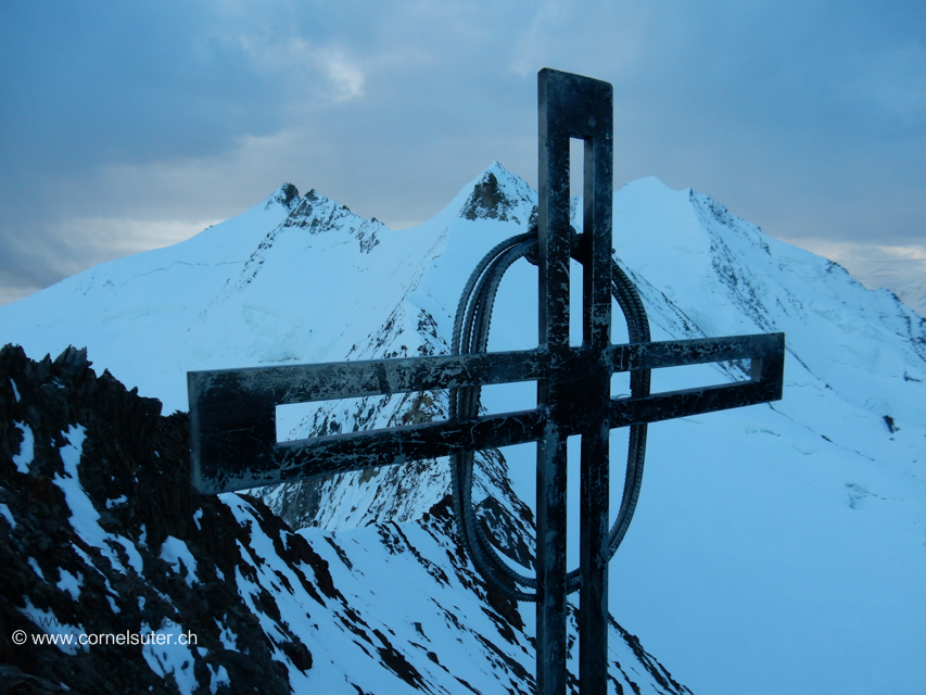 Das Gipfelkreuz Dirruhorn 4035m. Links beim Kreuz die 3 nächsten Gipfel Hobärghorn 4219m – Stecknadelhorn 4241m – Nadelhorn 4327m. Rechts beim Kreuz der Dom 4545m.