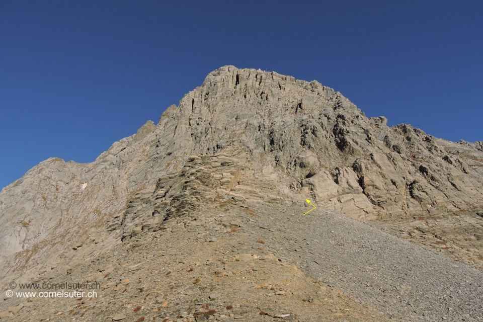 Der Einstieg zur Südostkante befindet sich hinter einem vorstehenden Felsblock  von der Gipfelwand, dieser Block umgeht man rechts (östlich).